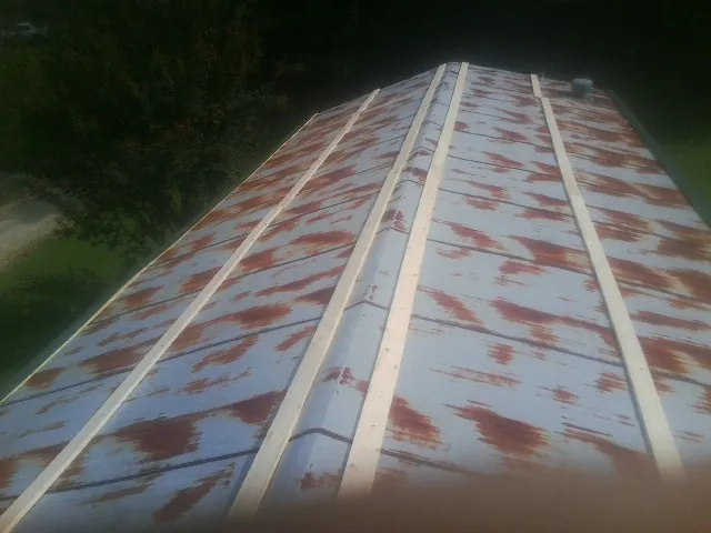 Rusted metal roof panels with new wood purlins before replacement — Storm Damage Roof Repair in Velva by Roofing Brothers