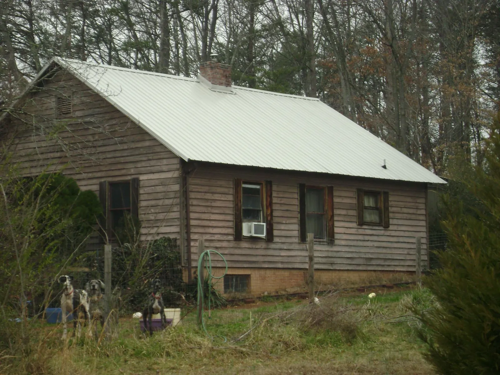 White metal roof on an old wood sided farmhouse, from a Metal Roof Installation job in Velva